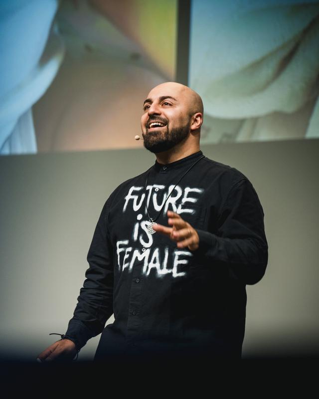 Ali Mahlodji auf der Bühne im Shirt „Future is female“